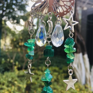 Macro detail of suncatcher butterfly with green crystal beads and moon charms