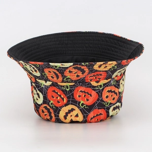 Detail of Halloween bucket hat featuring pumpkin patterns and spider web print on white fabric