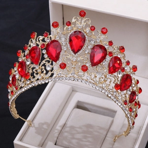Detailed macro shot of a golden baroque crown with red crystals in a jewelry box
