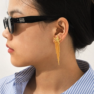 Detail of golden starfish earrings with long metal chain tassels worn by a model