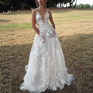 White V-neck lace wedding dress with floral embroidery and puffy skirt on outdoor grass