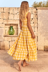 Detail of yellow and white plaid maxi dress showing backless smocked design in sunlight