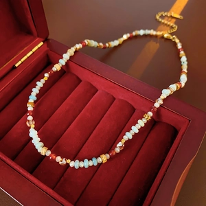 Close-up of colorful crystal beaded necklace with gold clasp on red velvet jewelry box