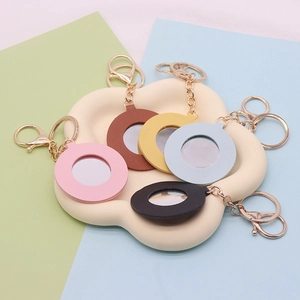 Detailed view of colorful PU leather heart mirror keychains with gold metal rings