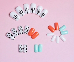 Flat lay of press-on nails with cow print, cactus designs and solid summer colors