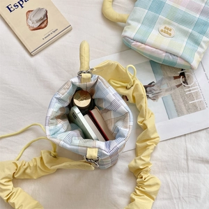 Detail of plaid water bottle bag with ruffled strap showing spacious interior capacity