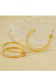 Detail of 18K gold plated C-shaped earrings with double-row beaded texture design