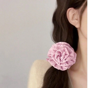 Close-up of a pink hollow-out lace rose hair scrunchie worn on a model's hair