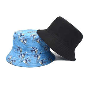 Detail showing the reversible bucket hat with blue tropical fish pattern and solid black side