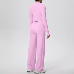 Détail de l'ensemble de yoga rose avec haut court à manches longues et pantalon large