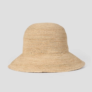 Close-up of handmade raffia sun hat with wide brim and fine woven texture