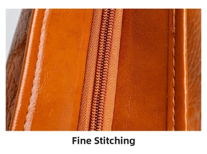 Close-up of durable metal zipper and fine stitching on orange-brown crocodile tote bag