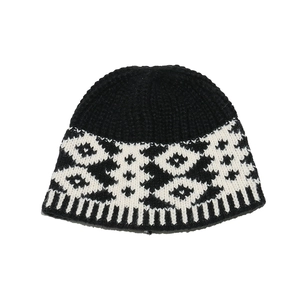 Detail view of winter knitted hat showing geometric jacquard pattern and ribbed hem