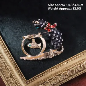 Detail view of cat and fishbowl brooch with 4.3x3.8cm dimensions on black velvet