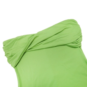 Detail of green knit dress showing twist knot pleated neckline and stretchy fabric texture