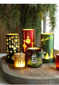 Detail of Christmas LED candles with reindeer cutouts and festive glass jar on wood tray