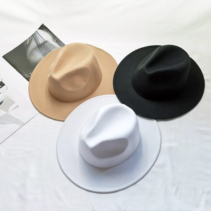 Επίπεδη λήψη από μάλλινα καπέλα fedora σε χακί, μαύρο και λευκό πάνω σε μαλακό ύφασμα