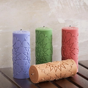 Detailed relief patterns of sun and moon on four cylindrical textured scented candles