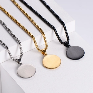 Three minimalist Queen Elizabeth II steel necklaces in gold, silver, and black on pedestals
