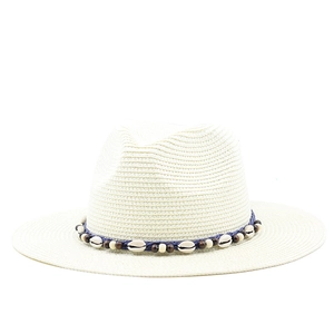 Close-up of Panama straw hat featuring seashell and wooden bead trim on navy band
