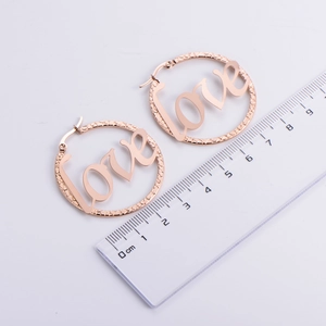 Rose gold LOVE earrings with 4.5cm large hoops shown next to a ruler for scale