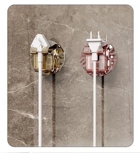 Wall-mounted wave textured plug organizers in amber and pink for tidy cord storage