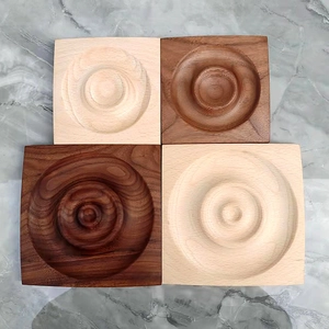 Macro view of square beech and walnut wood coasters with circular groove on marble background