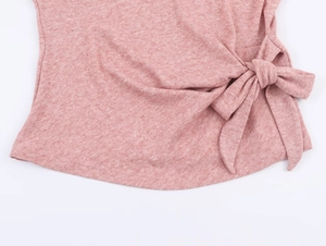 Détail macro du haut en maille rose avec nœud latéral et texture de tissu chiné