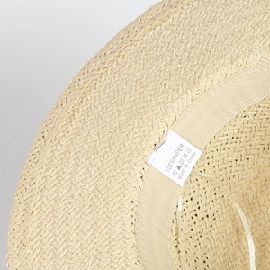 Détail de la bande de confort et étiquette 100% papier sur le chapeau de paille beige