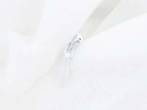 Gros plan détaillé sur la fermeture éclair invisible de la robe en dentelle blanche