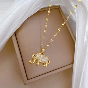 Detailed close-up of a golden elephant pendant with sparkling crystals on silk fabric