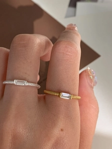 Close-up of a twisted s925 silver ring with a rectangular cubic zirconia on finger