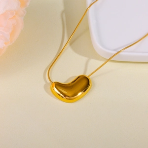 Close-up of a polished golden bean pendant on a sleek stainless steel snake chain