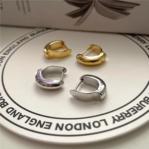 Macro shot of gold and silver chunky 925 sterling silver hoop earrings on a tray