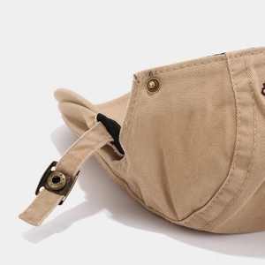 Detailed view of the adjustable metal buckle and strap on a khaki cotton ivy flat cap