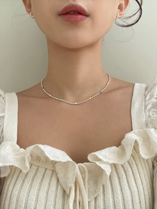 Close-up of minimalist 925 silver beaded necklace with colorful beads on a model