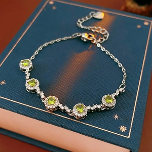 Close-up of green zircon silver bracelet on luxury blue velvet vintage jewelry box