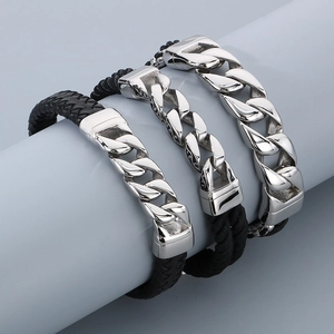 Close-up of men's leather bracelets with magnetic clasps and steel Cuban chain detailing