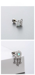 Détail de boucles d'oreilles en acier avec papillon opale et pendentifs attrape-rêves