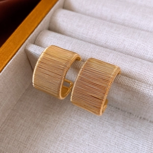 Macro shot of 18k gold plated earrings with a fine horizontal wire-wrapped texture