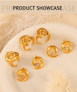 Detailed shot of gold spiral twist rings and matching zircon stud earrings in a tray