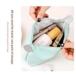 Detail of mint green PU dumpling cosmetic bag with cat ear design and ring zipper