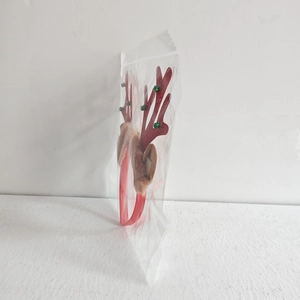 Detailed view of red reindeer antler headband with green beads in clear plastic packaging