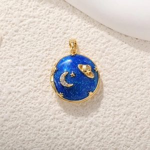 Detailansicht eines runden blauen Emaille-Anhängers mit goldenen Mond- und Sternmotiven