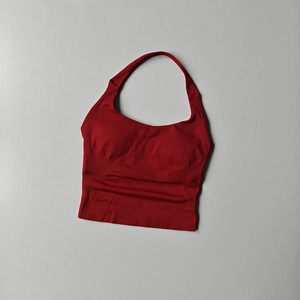 Macro view of seamless red yoga tank top showing elastic knit texture and wide ribbed hem