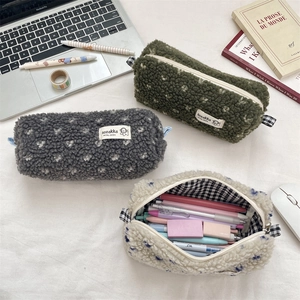 Détail de la trousse en peluche montrant la texture douce et la doublure à carreaux