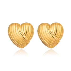 Detailed macro view of gold heart stud earrings featuring a textured striped metal surface
