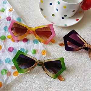 Flat lay of colorful butterfly cat-eye sunglasses with gradient lenses on a desk
