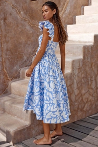 Detailaufnahme von blauem Boho-Kleid mit Rüschenärmeln auf Steintreppen