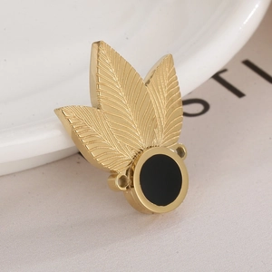Golden clover leaf pendant with black circular inlay and polished metal texture